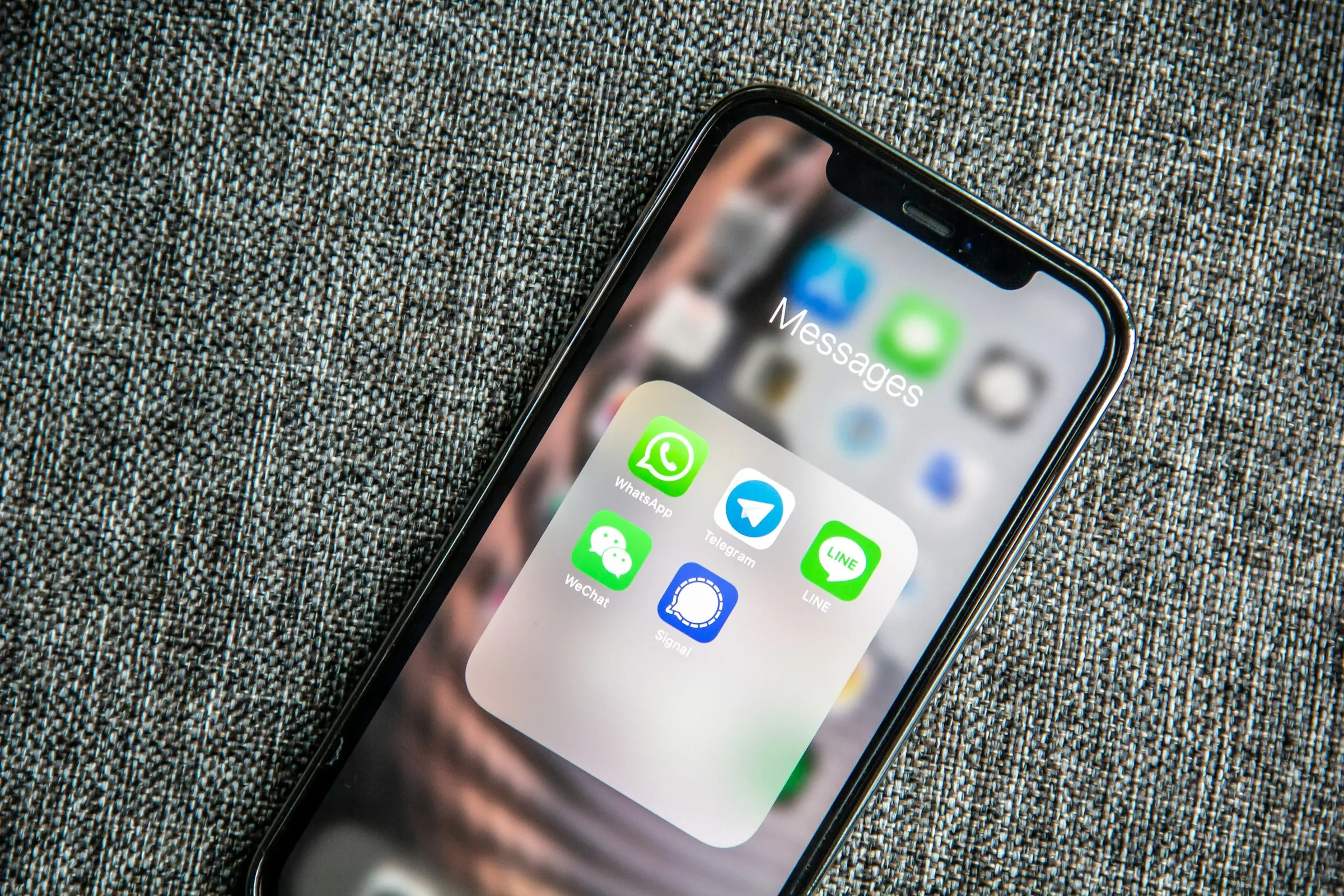 Person holding smartphone showing WhatsApp messaging interface